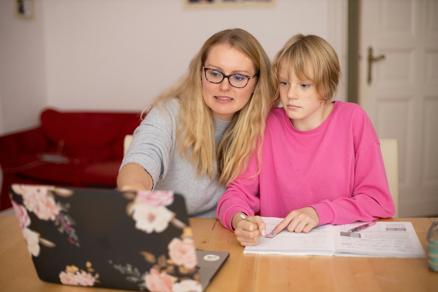 Žena a dieťa sa spoločne učia pri notebooku a poznámkovom bloku.